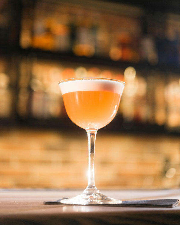 Peach colored cocktail with foam